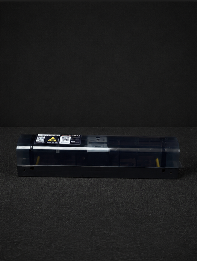 Blue-toned laser printer toner cartridge resting on a dark surface against a black backdrop